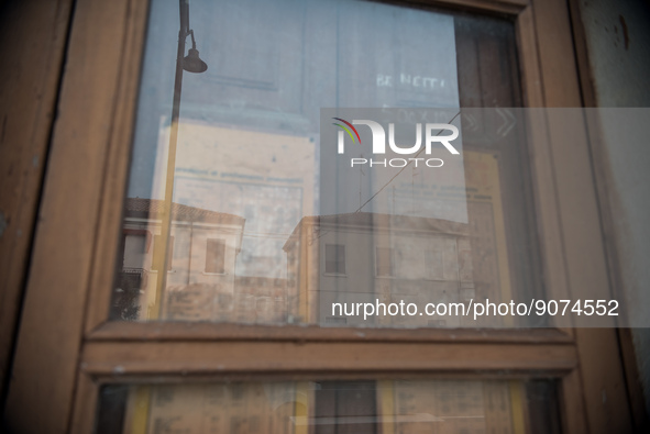 Some buildings reflected in the old window of an abandoned building along Viale Roma, one of the main streets of Tresigallo, in the province...