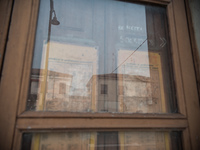 Some buildings reflected in the old window of an abandoned building along Viale Roma, one of the main streets of Tresigallo, in the province...