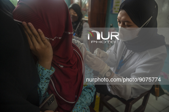 An officer injects a vaccine to a student on child immunization at SD Inpres Palupi, Palu City, Central Sulawesi Province, Indonesia on Octo...