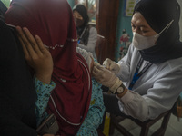 An officer injects a vaccine to a student on child immunization at SD Inpres Palupi, Palu City, Central Sulawesi Province, Indonesia on Octo...