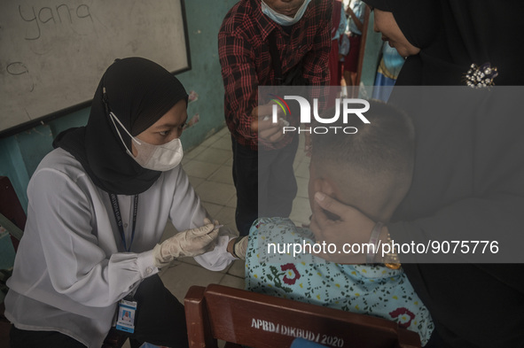 An officer injects a vaccine to a student on child immunization at SD Inpres Palupi, Palu City, Central Sulawesi Province, Indonesia on Octo...