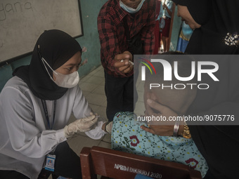 An officer injects a vaccine to a student on child immunization at SD Inpres Palupi, Palu City, Central Sulawesi Province, Indonesia on Octo...