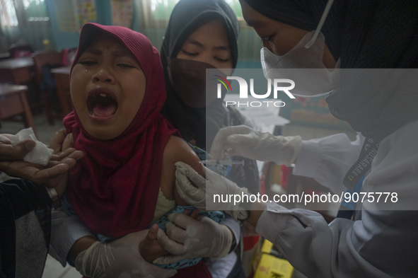 An officer injects a vaccine to a student on child immunization at SD Inpres Palupi, Palu City, Central Sulawesi Province, Indonesia on Octo...