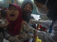 An officer injects a vaccine to a student on child immunization at SD Inpres Palupi, Palu City, Central Sulawesi Province, Indonesia on Octo...