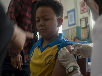 An officer injects a vaccine to a student on child immunization at SD Inpres Palupi, Palu City, Central Sulawesi Province, Indonesia on Octo...