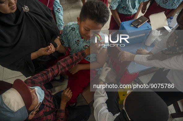 A health worker prepares a vaccine injection for a student on child immunization at SD Inpres Palupi, Palu City, Central Sulawesi Province,...