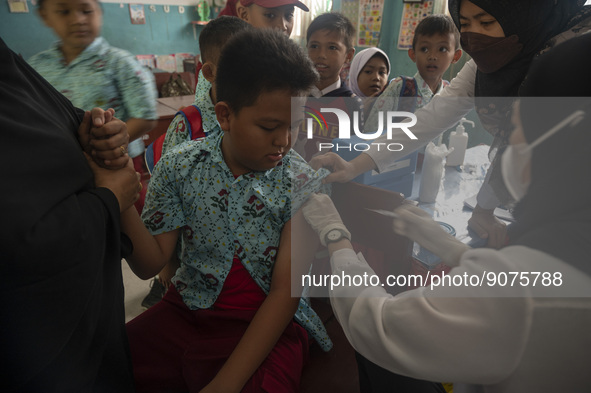 An officer injects a vaccine to a student on child immunization at SD Inpres Palupi, Palu City, Central Sulawesi Province, Indonesia on Octo...