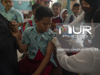 An officer injects a vaccine to a student on child immunization at SD Inpres Palupi, Palu City, Central Sulawesi Province, Indonesia on Octo...