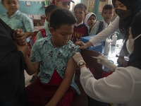 An officer injects a vaccine to a student on child immunization at SD Inpres Palupi, Palu City, Central Sulawesi Province, Indonesia on Octo...