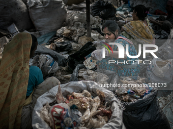 Women are sorting out the plastic bags at Dhapa waste dumping ground, Kolkata, India. January 17, 2015.  *** Go to http://nurphoto.com/en/re...