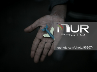 A kid has found a toy plane in the waste dumping ground. Dhapa, Kolkata, India. January 20, 2015.  *** Go to http://nurphoto.com/en/reportag...