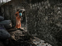 A woman is going through a punch on the Boundary wall of waste dumping ground, Dhapa, Kolkata, India. January 20, 2015.  *** Go to http://nu...