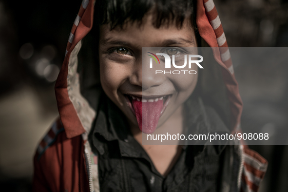 A kid is showing his red tongue at Dhapa west dumping ground, Kolkata, India. January 20, 2015.  *** Go to http://nurphoto.com/en/reportages...