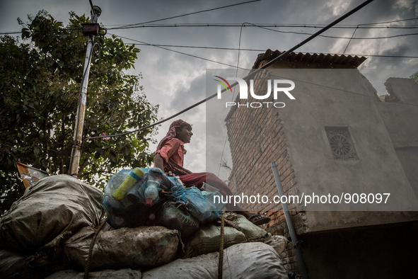 A young boy is sitting obove the collected wastes from Dhapa west dumping ground. Dhapa, Kolkata, India. September 18, 2015.  *** Go to http...