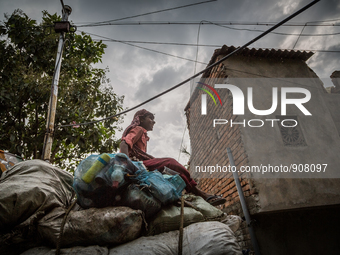 A young boy is sitting obove the collected wastes from Dhapa west dumping ground. Dhapa, Kolkata, India. September 18, 2015.  *** Go to http...