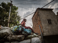 A young boy is sitting obove the collected wastes from Dhapa west dumping ground. Dhapa, Kolkata, India. September 18, 2015.  *** Go to http...