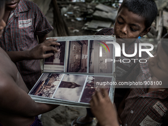 Kids found a photo album from the waste dumping ground, Dhapa, Kolkata, India. September 11, 2015.  *** Go to http://nurphoto.com/en/reporta...