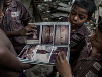 Kids found a photo album from the waste dumping ground, Dhapa, Kolkata, India. September 11, 2015.  *** Go to http://nurphoto.com/en/reporta...