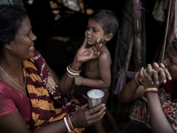 A female scavenger is feeding her kid milk at the waste dumping ground. Dhapa, Kolkata, India. September 10, 2015.  *** Go to http://nurphot...