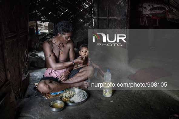 A guard of waste dumping ground is feeding his grand son during lunch time. Dhapa, Kolkata, India. September 17, 2015.  *** Go to http://nur...