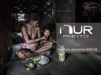 A guard of waste dumping ground is feeding his grand son during lunch time. Dhapa, Kolkata, India. September 17, 2015.  *** Go to http://nur...