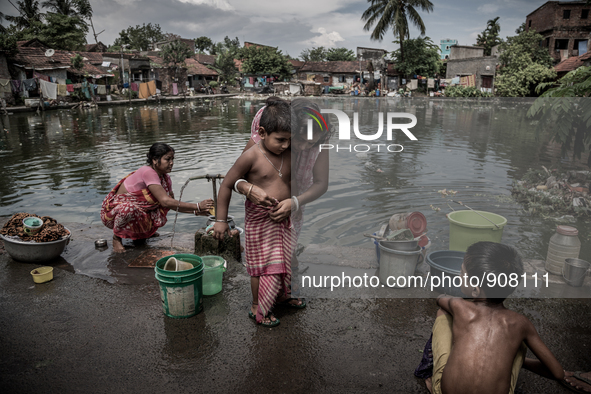 A mother is tying gamcha to her kid. Dhapa, Kolkata, India. September 14, 2015.  *** Go to http://nurphoto.com/en/reportages/51754 to see mo...