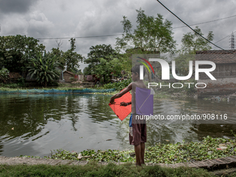 A kid is preparing his kites. Dhapa, Kolkata, India. September 11, 2015.  *** Go to http://nurphoto.com/en/reportages/51754 to see more ****...