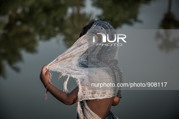 A kid is hiding his face at Dhapa, Kolkata, India. September 18, 2015.  *** Go to http://nurphoto.com/en/reportages/51754 to see more **** 