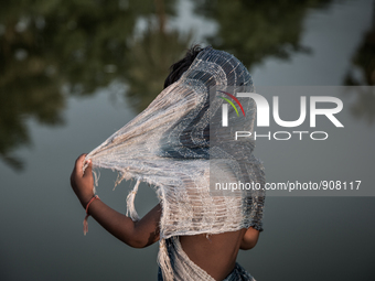 A kid is hiding his face at Dhapa, Kolkata, India. September 18, 2015.  *** Go to http://nurphoto.com/en/reportages/51754 to see more **** (