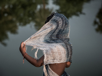 A kid is hiding his face at Dhapa, Kolkata, India. September 18, 2015.  *** Go to http://nurphoto.com/en/reportages/51754 to see more **** (