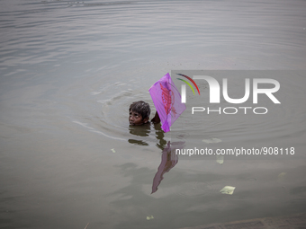 A kid is saving his kite from the water. Dhapa, Kolkata, India. September 18, 2015.  *** Go to http://nurphoto.com/en/reportages/51754 to se...