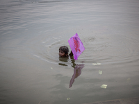 A kid is saving his kite from the water. Dhapa, Kolkata, India. September 18, 2015.  *** Go to http://nurphoto.com/en/reportages/51754 to se...