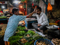 A Hindu priest anoints a vegetable seller with holy sandalwood paste in order to wish good luck for his business, at a marketplace in Kolkat...