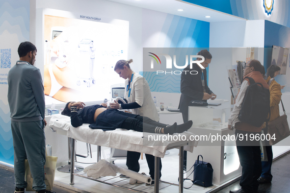 A fairgoer is seen scanned her stomach for a ultrasonic device  during the opening day of Medica 2022, a medical technology and health care...