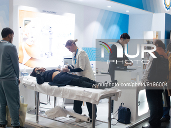 A fairgoer is seen scanned her stomach for a ultrasonic device  during the opening day of Medica 2022, a medical technology and health care...