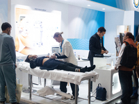 A fairgoer is seen scanned her stomach for a ultrasonic device  during the opening day of Medica 2022, a medical technology and health care...