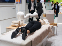 a fairgoer is seen trying out the massage robot  during the opening day of Medica 2022, a medical technology and health care exhibition in D...