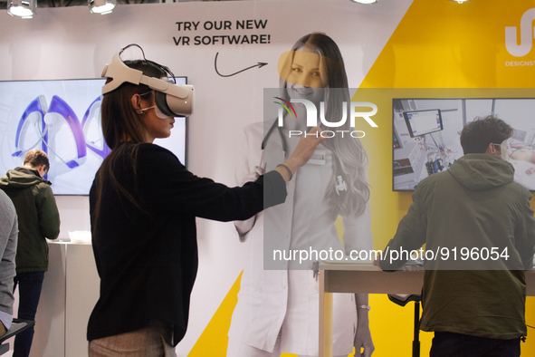 a fairgoer is seen trying out an augmented reality (AR) headset  during the opening day of Medica 2022, a medical technology and health care...