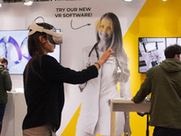 a fairgoer is seen trying out an augmented reality (AR) headset  during the opening day of Medica 2022, a medical technology and health care...