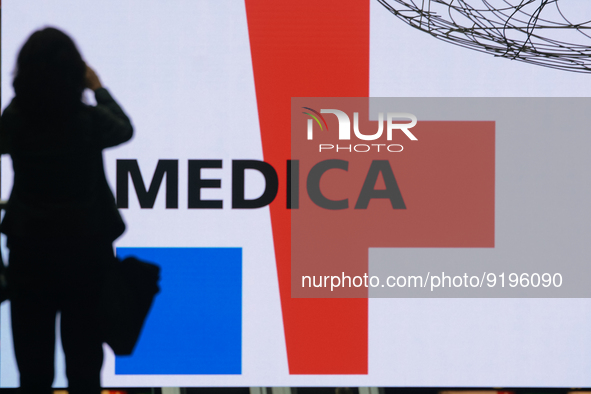 a fairgoer is seen take picture of the logo of Medica exhibition  during the opening day of Medica 2022, a medical technology and health car...