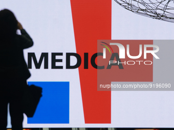 a fairgoer is seen take picture of the logo of Medica exhibition  during the opening day of Medica 2022, a medical technology and health car...