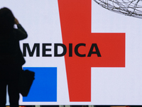 a fairgoer is seen take picture of the logo of Medica exhibition  during the opening day of Medica 2022, a medical technology and health car...