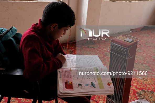 Students read inside a class room as heating facilities are installed in a private school in Baramulla Jammu and Kashmir India on 18 Novembe...