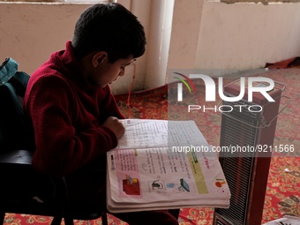 Students read inside a class room as heating facilities are installed in a private school in Baramulla Jammu and Kashmir India on 18 Novembe...