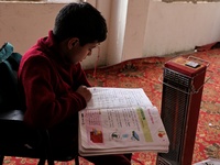 Students read inside a class room as heating facilities are installed in a private school in Baramulla Jammu and Kashmir India on 18 Novembe...