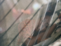 Rozina (19), is seen inside a mosquito net as she is under treatment for dengue fever at a special ward in Dhaka, Bangladesh on November 18,...