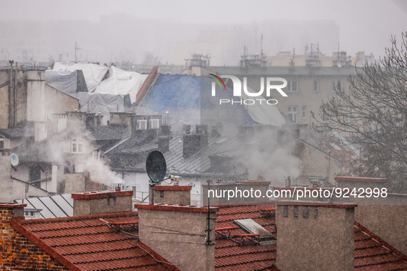 Smoke comes out of households' chimneys while the first snow is falling in Krakow, Poland, on November 24, 2022. Poland is one of the most p...