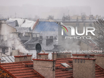 Smoke comes out of households' chimneys while the first snow is falling in Krakow, Poland, on November 24, 2022. Poland is one of the most p...