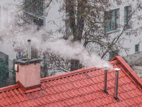 Smoke comes out of households' chimneys while the first snow is falling in Krakow, Poland, on November 24, 2022. Poland is one of the most p...