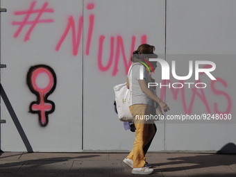 A woman walks past slogans on metal fences in Mexico City's Zócalo to mark the International Day for the Elimination of Violence against Wom...
